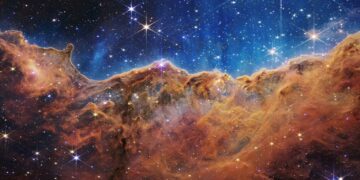 The edge of a nearby stellar nursery called NGC 3324, found at the northwest corner of the Carina Nebula, forms the “mountains” and “valleys” spanning this image captured by the James Webb Space Telescope.